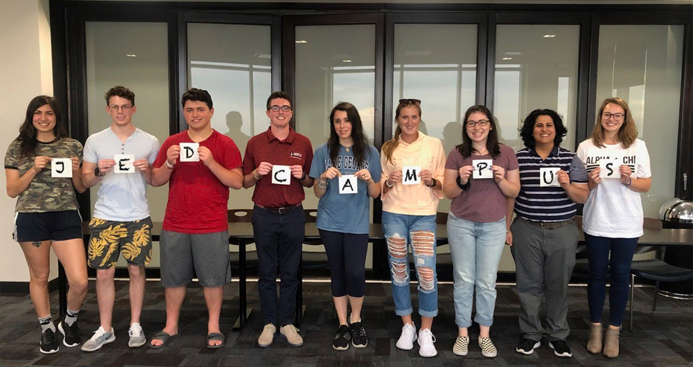 students holding JED Campus sign 