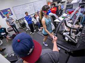 Student on treadmill wearing a mask