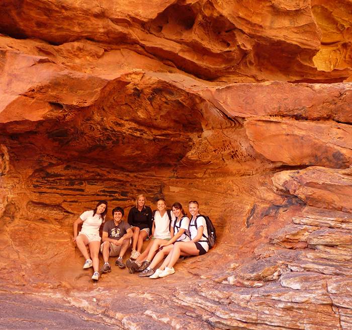 students sitting in a cave