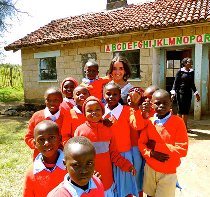 student with a group of children abroad