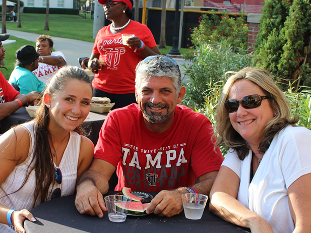 Three people sitting at a table smiling 