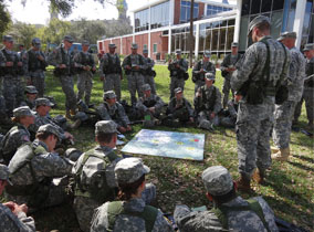 ROTC cadets in a circle looking at a map
