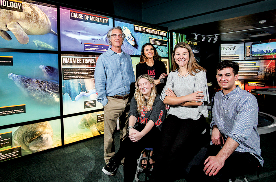 Group photo of the professor and students inside the Manatee Viewing Center.