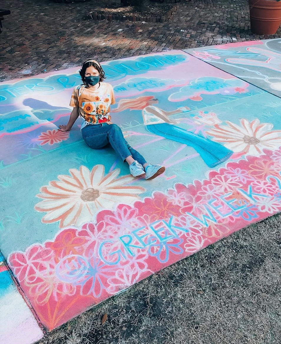 Girl sitting on a sidewalk chalk drawing