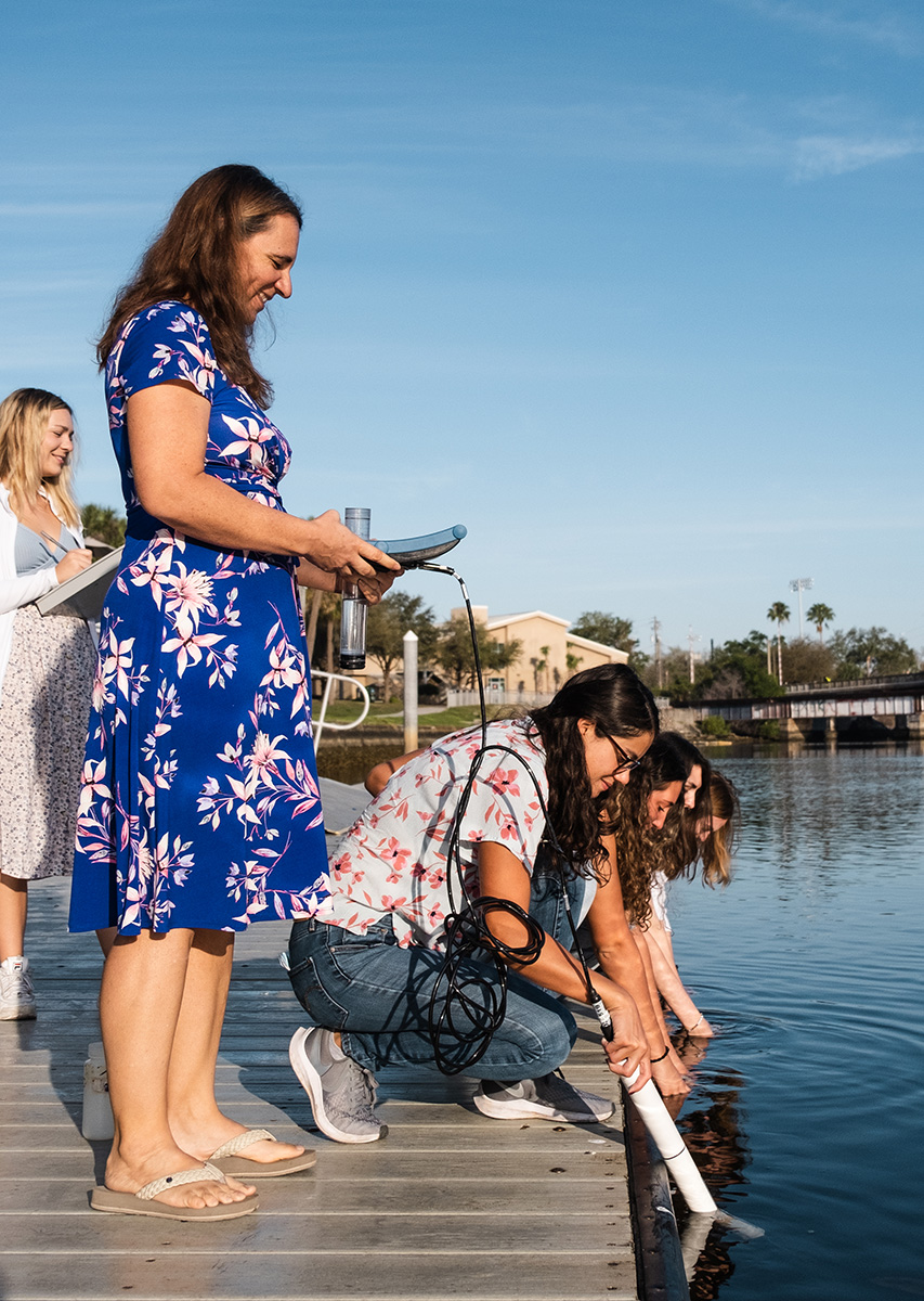 Froeschke testing water with her students