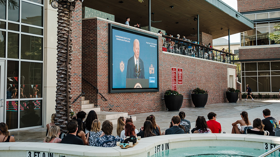 President Biden on the screen at the Riseman Aquatics Center.