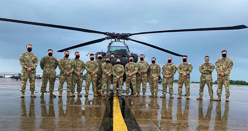 ROTC members in front of a helicopter