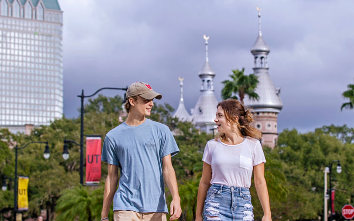 Two UT students walking with the minarets in the background